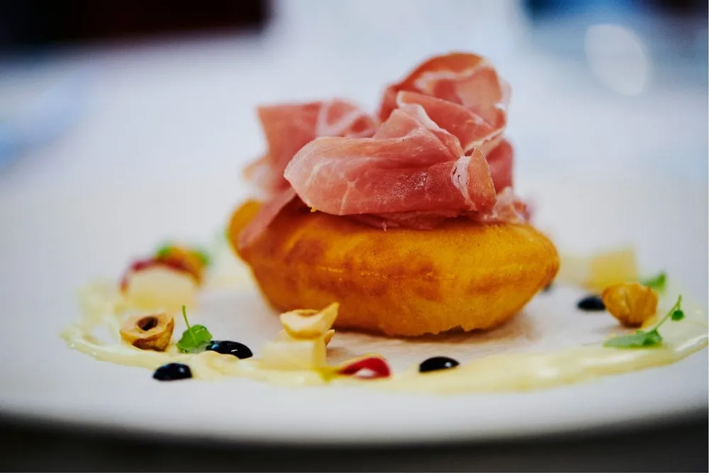 Pizza soufflée, Parma ham, candied pears, hazelnuts and parmesan cream